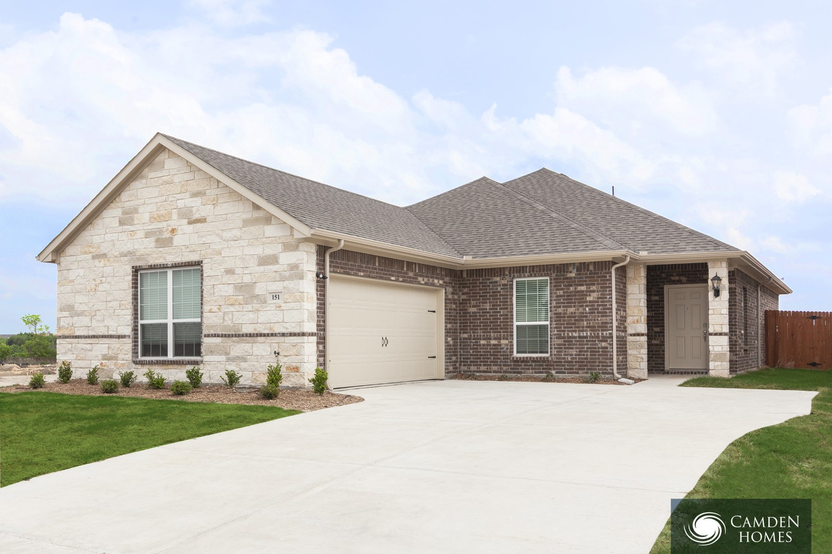 A house with a garage and a driveway in front of it.